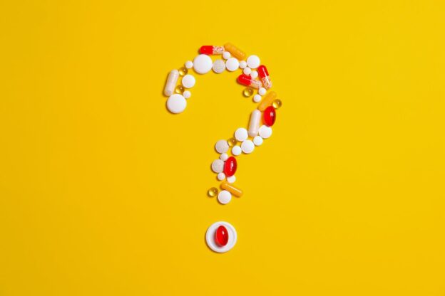 A question mark made of different pills on a yellow surface representing what is a speedball