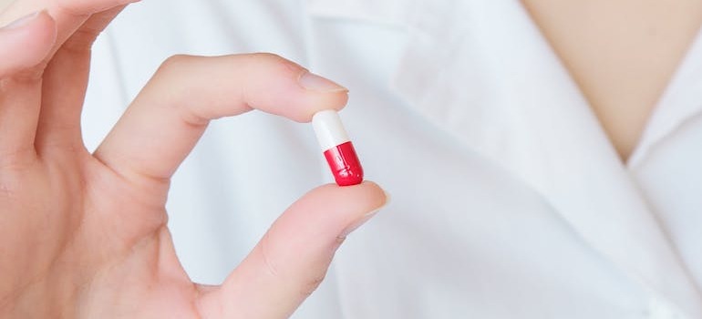 A person holding a pill explaining the drug to people and helping the with understanding gabapentin