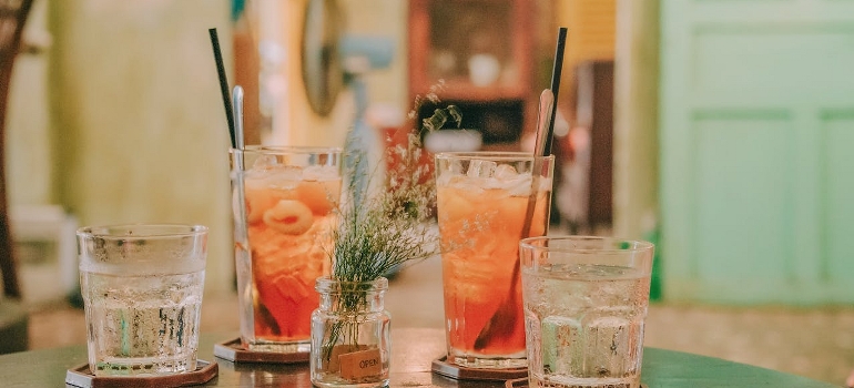 Alcoholic cocktails and sodas are served on the table.
