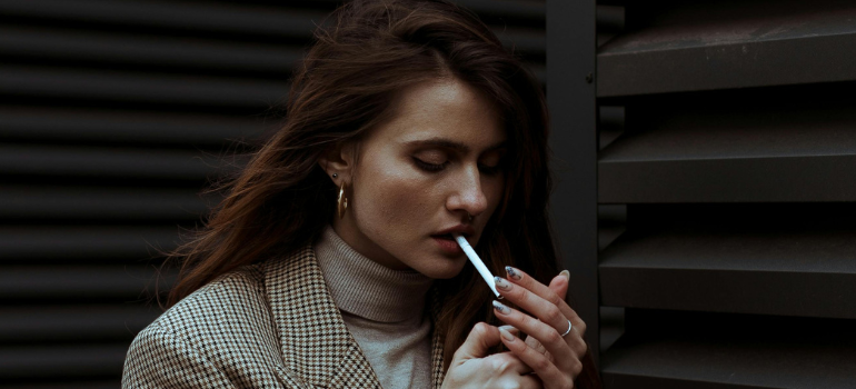 A young woman lighting up a cigarette