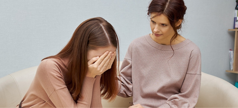 A patient cries while a therapist comforts them