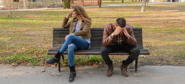 A couple in a fight sitting on a bench