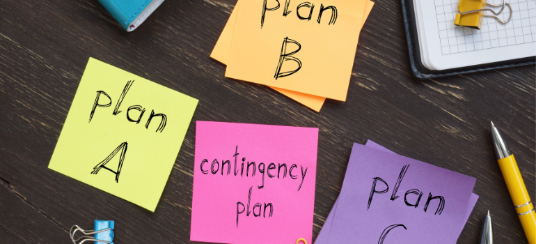 A desk looked at from above with post its that say plan A, plan B, and contingency plan