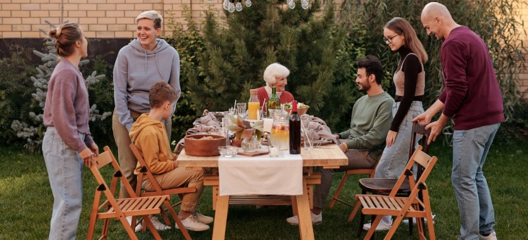 Happy family and friends having lunch in the garden can help you when you are Overcoming Addiction and Bipolar Disorder