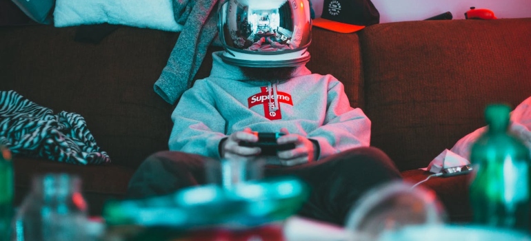 Guy with a helmet sitting and playing video games