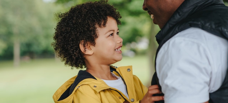 This man smiling to his kid in a park is how you need to Tell Your Kids You Are Going to a Rehab Center