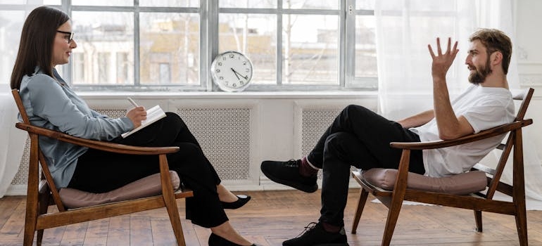 Man consulting his therapist on whether he should move in with his parents after rehab.