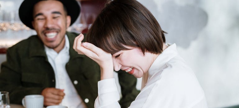 Two friends drinking coffee and laughing.