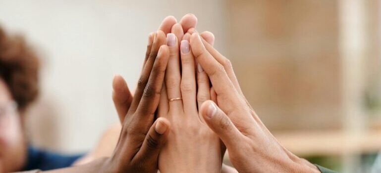 Multiple hands touching each other as a sign of support in psychotherapy sessions.