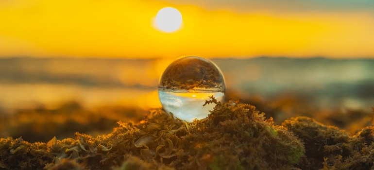 A clear ball on the beach with sunrise symbolizing bright future