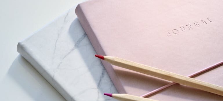 Journals and pencils on a white surface.