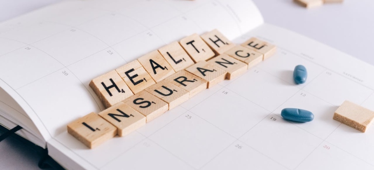 Health insurance wooden letters on a notebook