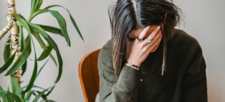 A young woman covering her face with her hand