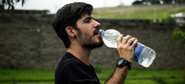 A man drinking water from a plastic bottle