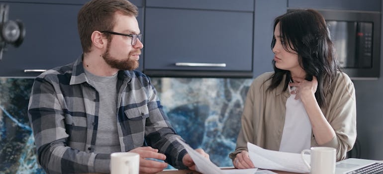 Couple discussing their bills and whether to move in with one of their parents after rehab.