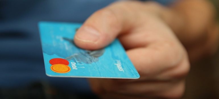 A man holding a blue MasterCard