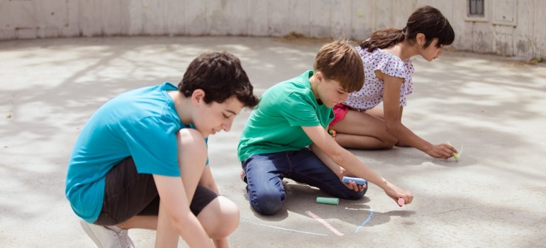 Children writing on the beach