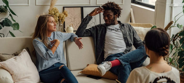 A woman and a man discussing things on a couch in the therapists' office