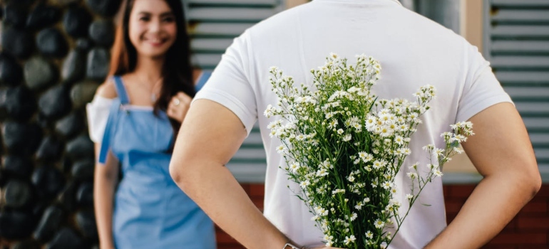 A man holding a flower for his girlfriend