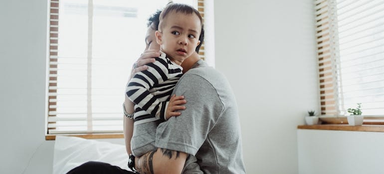 A parent holding a scared child showing addiction susceptibility across generation