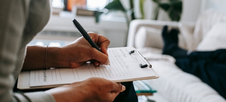 A psychologist writing on clipboard during session