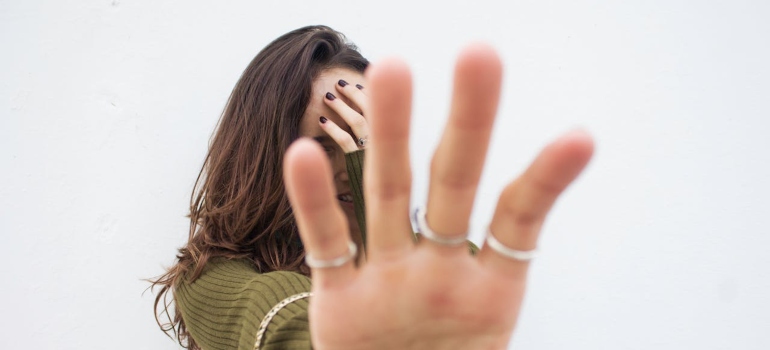 A young woman covers her face