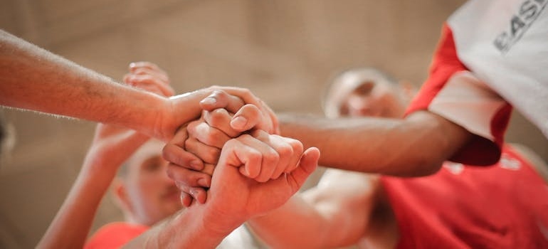 Basketball team members stacking hands.