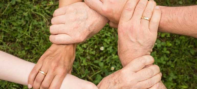 people holding each other's hands ready to To Give Back To Your Buckhannon Community After Getting Sober