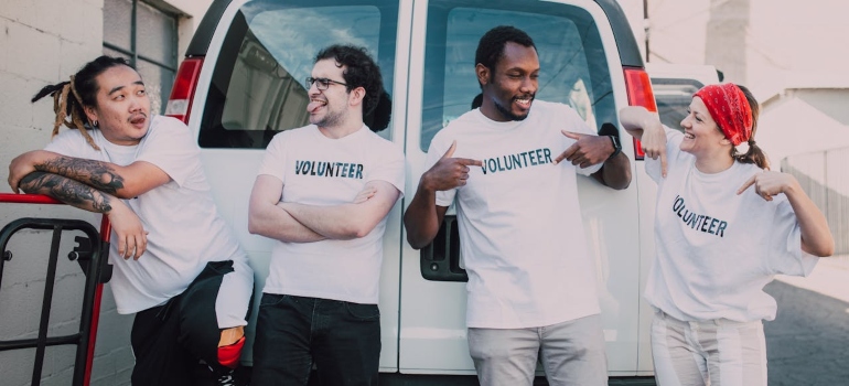 four volunteers standing in front of the van