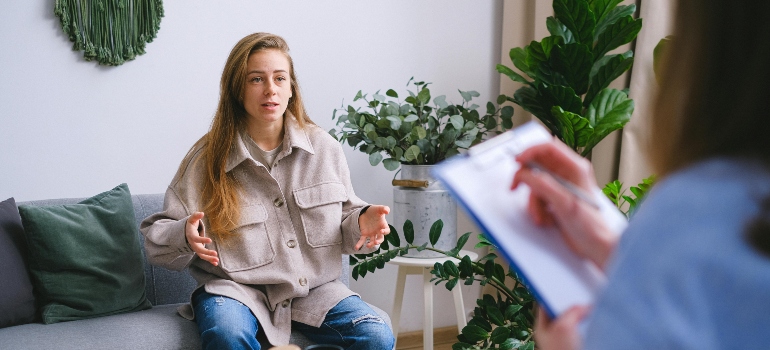 The woman in the grey jacket is explaining her problems to a psychologist.