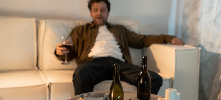 Man sitting on the couch and drinking a glass of wine.