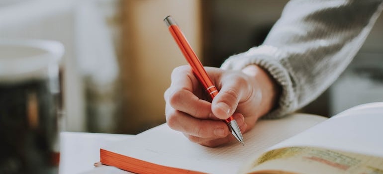 Person writing in a notebook.