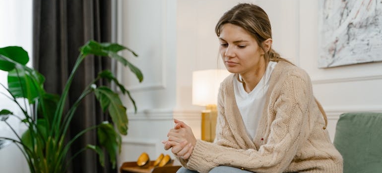 Woman seating on the couch and thinking.