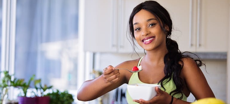 Woman eating a bowl of fruit.