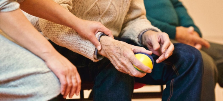 A woman holding a man's hand in a supportive manner