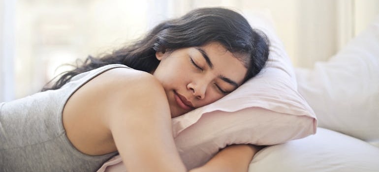 Woman holding a pillow while sleeping.