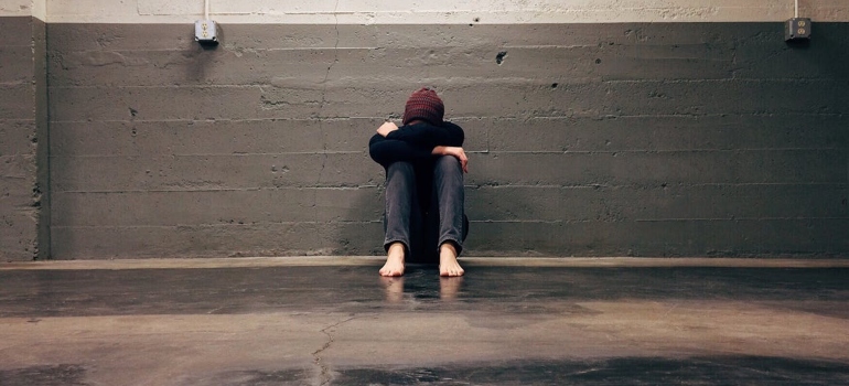 One of the Common Drugs That Can Cause Suicidal Thoughts are antidepressants used to treat depression that can manifest as a person sitting by themselves leaning on the wall