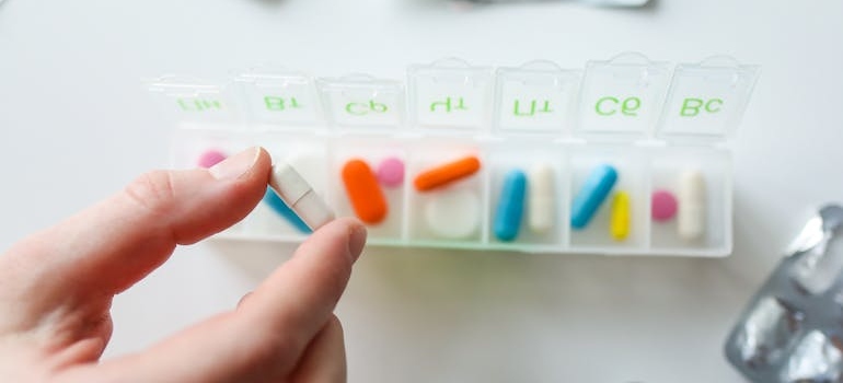 Woman taking a pill out of a box.