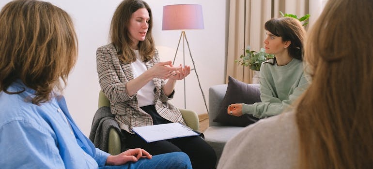 Psychologist talking to a group of patients in group therapy.