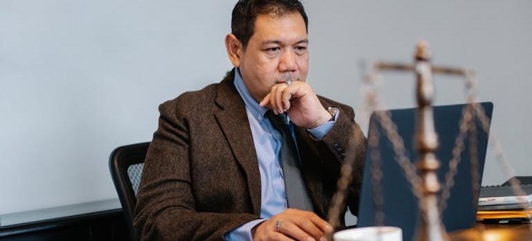 Lawyer sitting at a table and looking at his laptop.