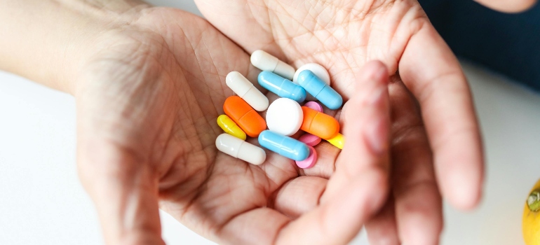 Colorful medicine pills on a person's hand, who's thinking about how to choose the right barbiturate rehab center.