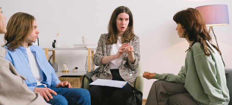 Four people are sitting on the couch during the group therapy.