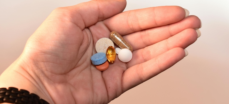 Person holding pills and capsules