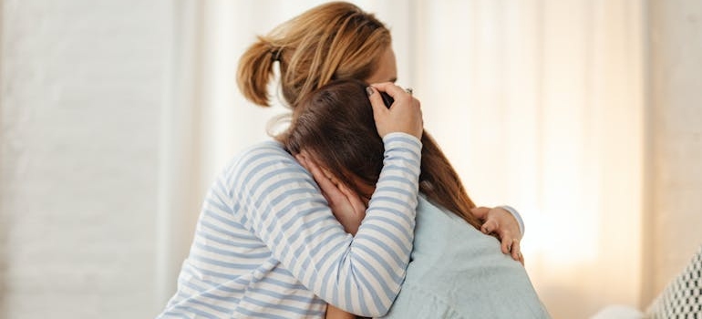 Woman hugging her crying daughter.