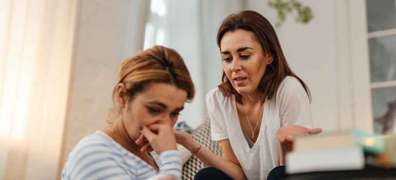 Worried women talking at home thinking about how to conduct an addiction intervention