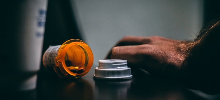 man's hand next to a box of medicines