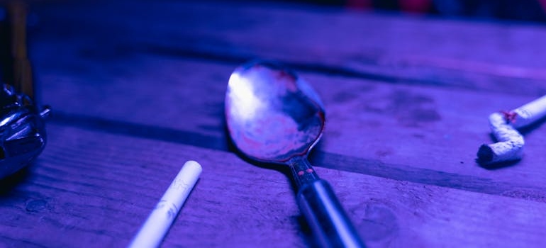 Cigarette next to a spoon.