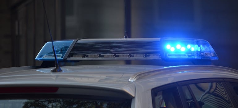 Police car with its blue light turned on.