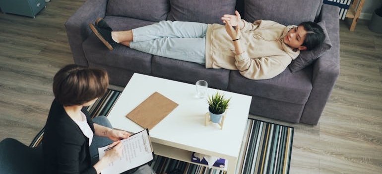 Woman lying on the couch during a therapy session and talking to her therapist.