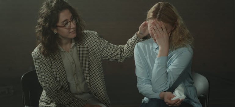 Woman supporting another woman during group therapy, talking about Fentanyl dangers.